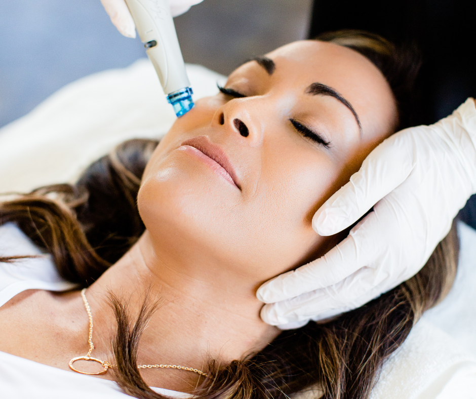 A woman receiving a professional facial treatment with a skincare device.